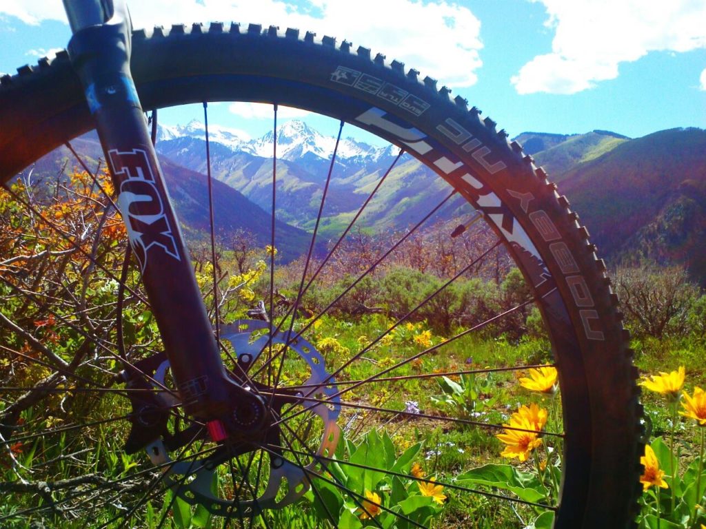 bike wheel up close with mountains in the background