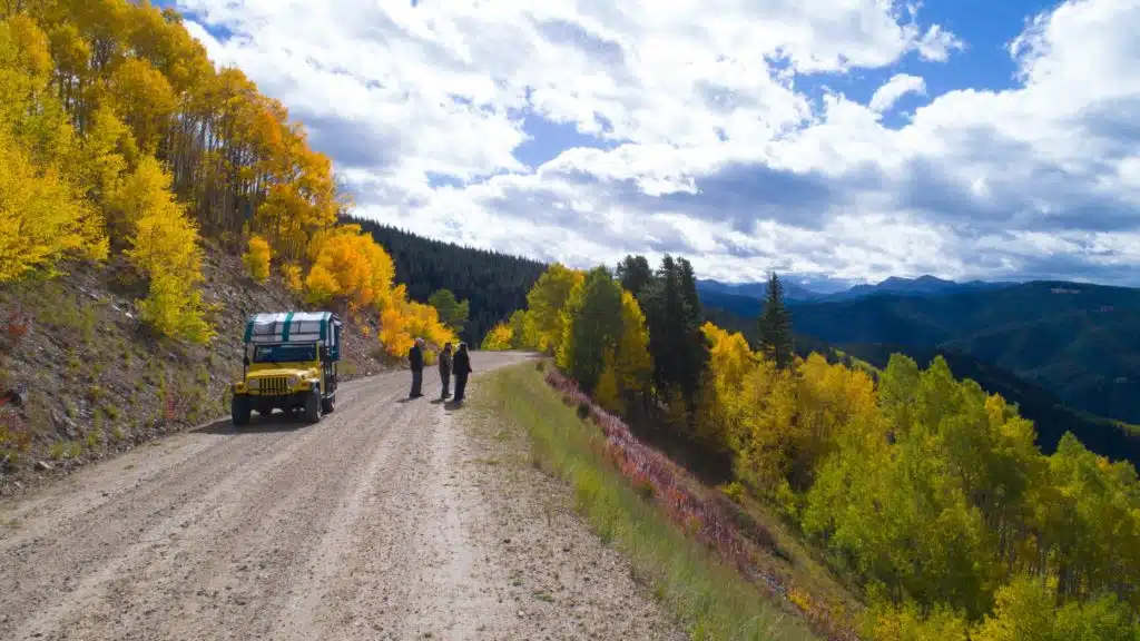 group next to jeep looking at view