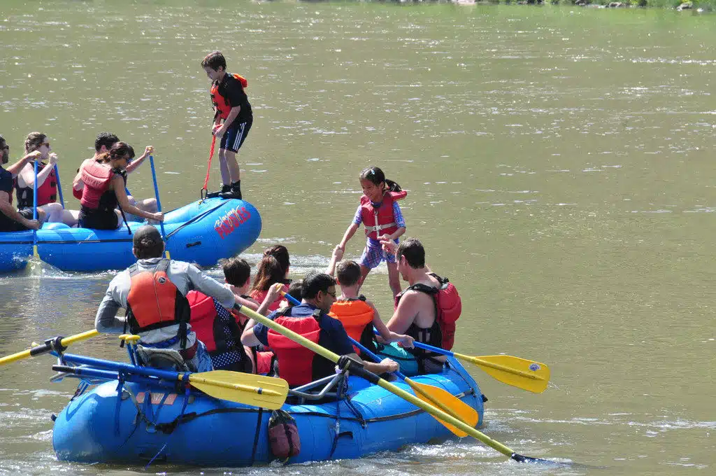 kids standing up in rafts